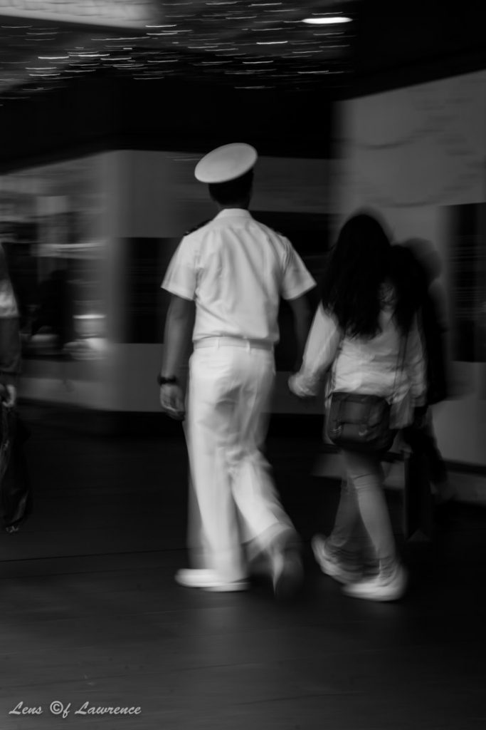 A candid shot of an off duty sailor and his girlfriend holding and hands and window shopping in Auckland New Zealand