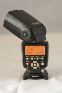 Yongnuo 560IV from behind showing flash head swivelled to about 45 degrees vertically and horizontally