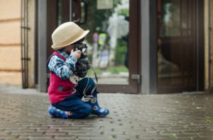 A humorous image of a very young photographer wearing a hat to depict the many hats a newborn photographer has to wear.