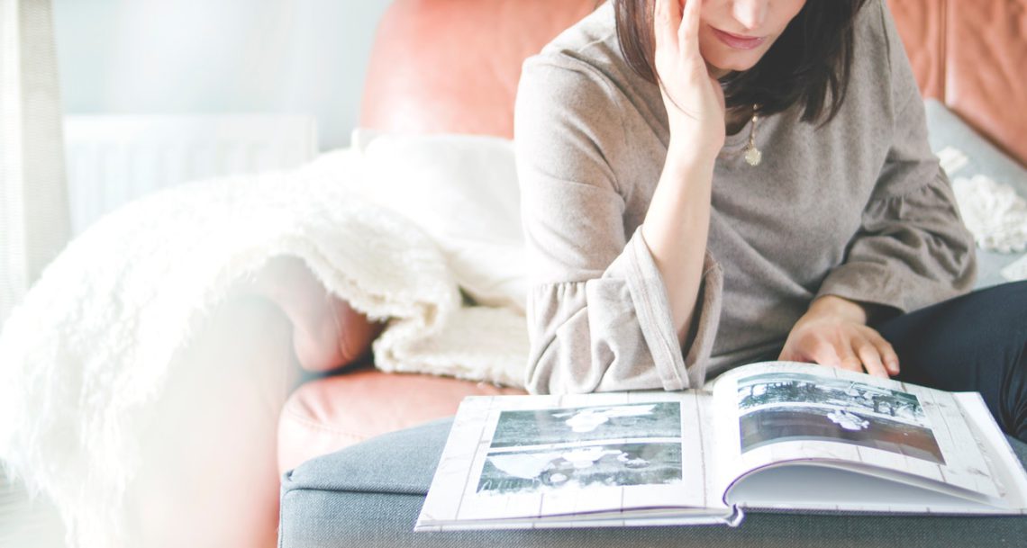 A woman looking at a Newborn photo album