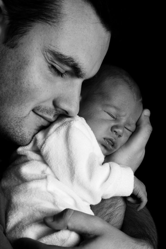A photo of a young father with his newborn taken under natural lighting