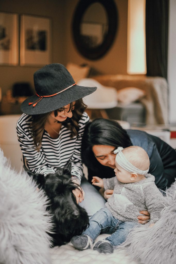 A photo of a young with her toddler and the photographer who took the newborn photos.