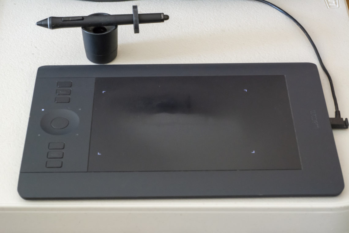 A photo of the Intuos Pro (small) showing the screen, the quick select buttons and the selection wheel plus the magical pen.